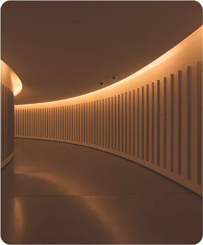 Curved hallway with warm LED cove lighting and modern architectural design